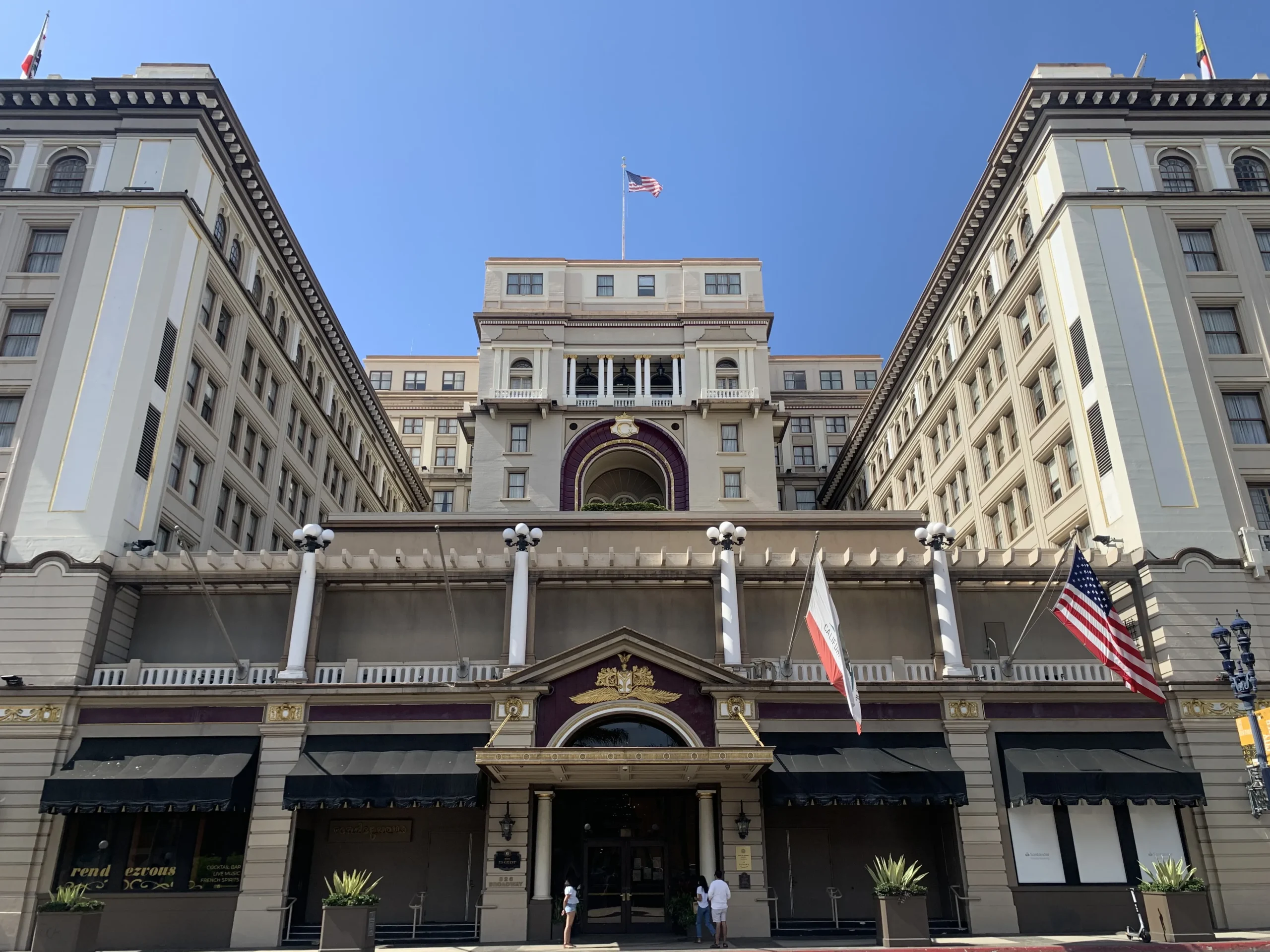 Ornate historic hotel building with US and California flags.