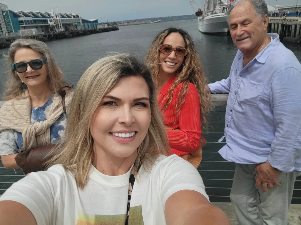 Group selfie on San Diego waterfront, showcasing landmarks and free walking tour experience.